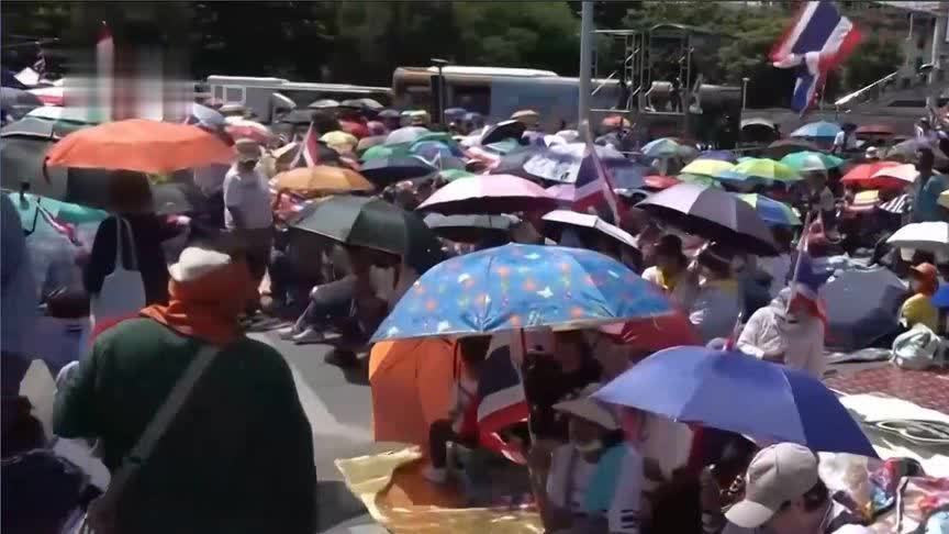 冒着酷暑、手举遮阳伞，泰国民众集会要求已停职总理佩通坦辞职