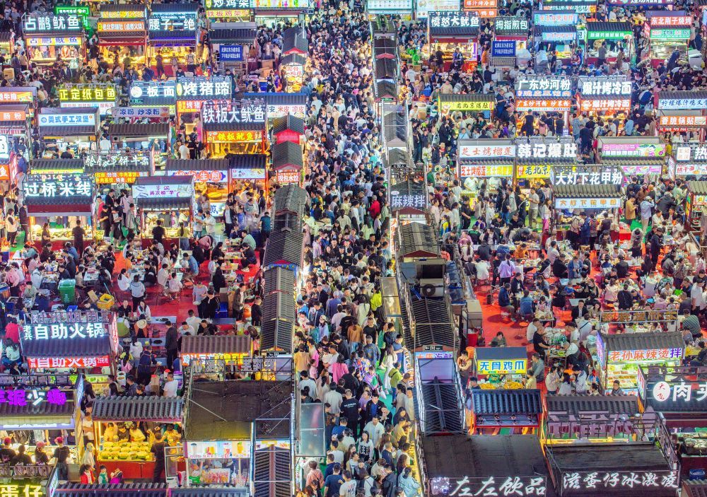 2024年4月21日,人们在正定县小商品夜市品尝美食(无人机照片)。新华社发(武志伟摄)