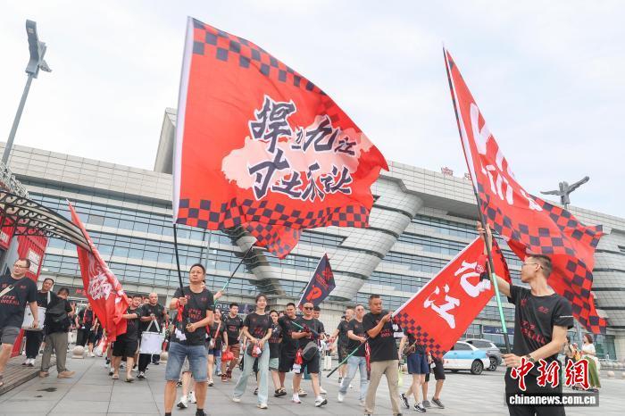 圖為8月2日，江西鷹潭北站，九江隊(duì)球迷走出車(chē)站后，揮舞球隊(duì)的助威旗幟。劉力鑫 攝
