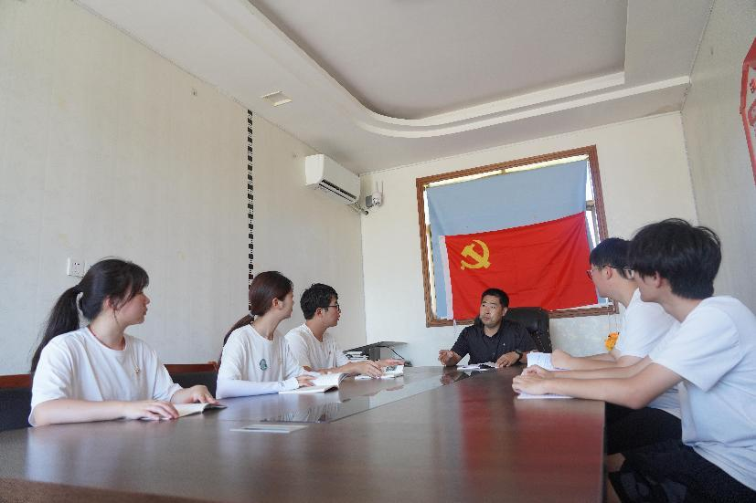 图为“渔之火乡村振兴团”成员聆听党支部讲解红色书籍 何嘉怡 供图
