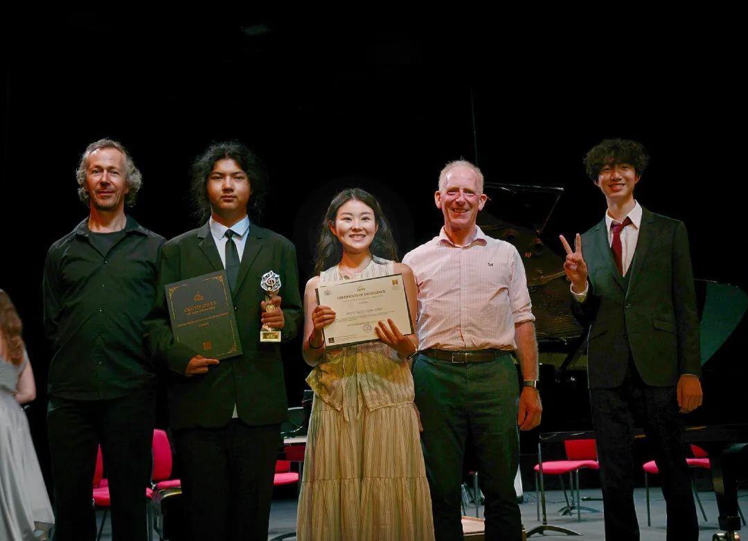 Lawrence Zhu（右一）获金奖，William Xie（左二）获银奖。两人与国际著名钢琴家Anthony Williams、指挥家Chris McCracken合影