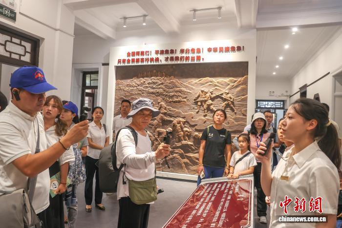 8月6日，江西庐山，民众在庐山抗战博物馆内聆听讲解。中新社记者 刘力鑫 摄
