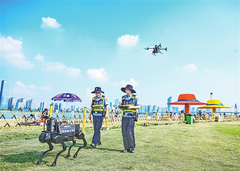 8月3日,南昌市公安局红谷滩分局警航中队民警带着机器狗和无人机,在摩天湾天然泳场巡逻。