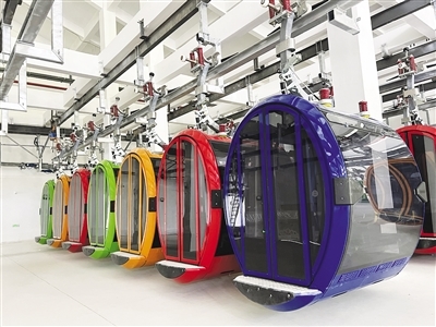 四色轿厢有序悬挂在室内车库轨道上