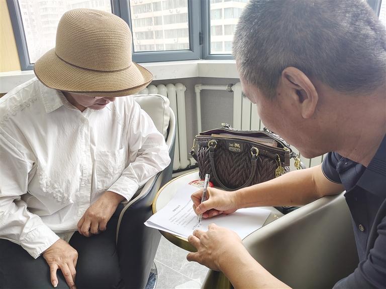 刘女士（左）与店方负责人签订协议