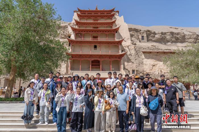 8月2日，两岸婚生子女暑期研学活动成员在位于甘肃省敦煌市的莫高窟九层楼前合影。中新社记者　李亚龙　摄