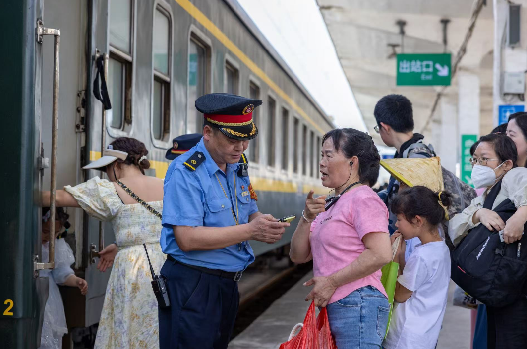 鹰潭站工作人员正在解答旅客咨询。（蔡紫妍 摄）