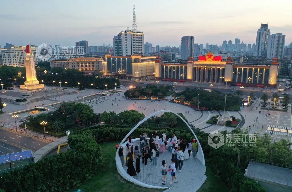 ▲游客在南昌武商MALL頂樓的觀景平臺上拍照打卡，觀賞八一南昌起義紀念塔、江西省美術館等地標建筑。大江網/大江新聞客戶端全媒體記者王祺 攝