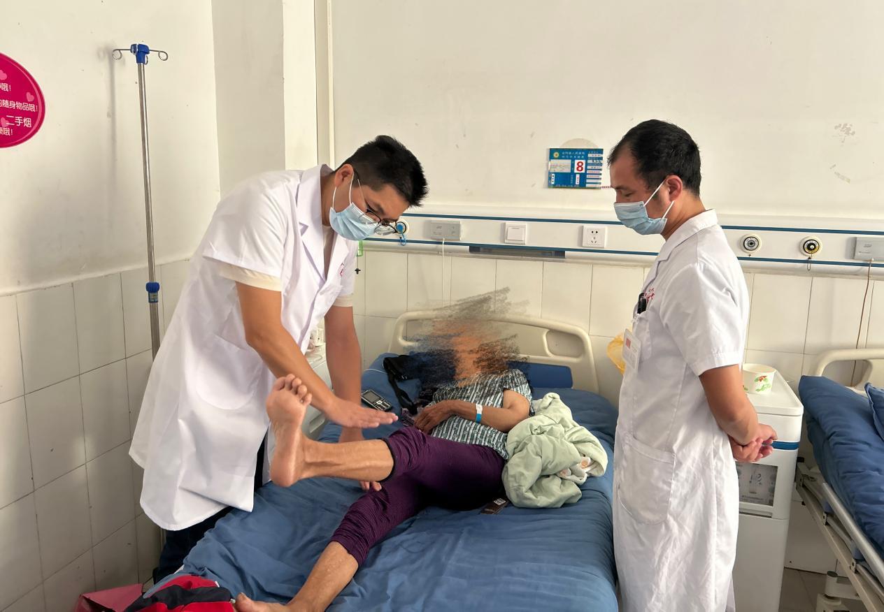 图为倪卫国医生（左一）为患者做检查