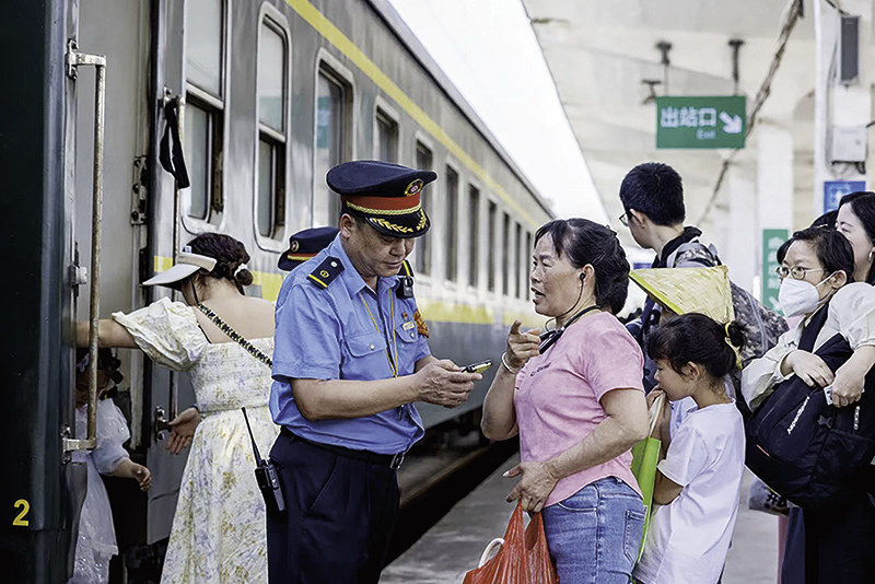 ▲鷹潭站工作人員正在解答旅客咨詢。 蔡紫妍 圖