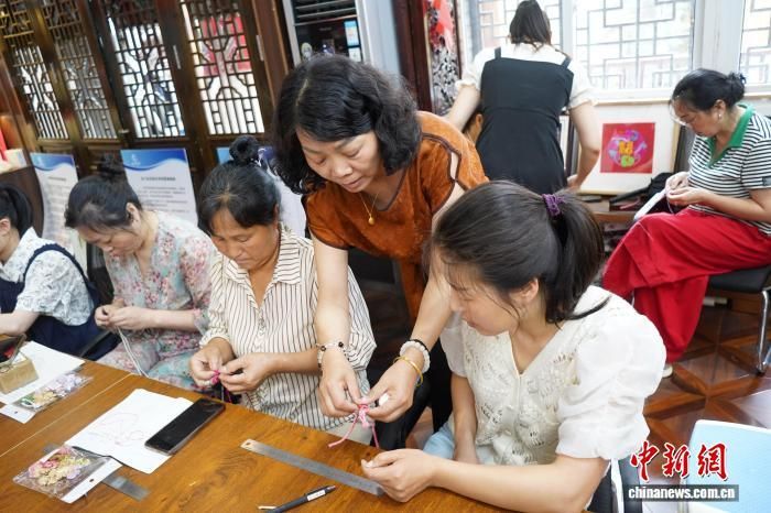 图为学员正在学习镇巴苗绣盘扣技艺。　邓先根 摄