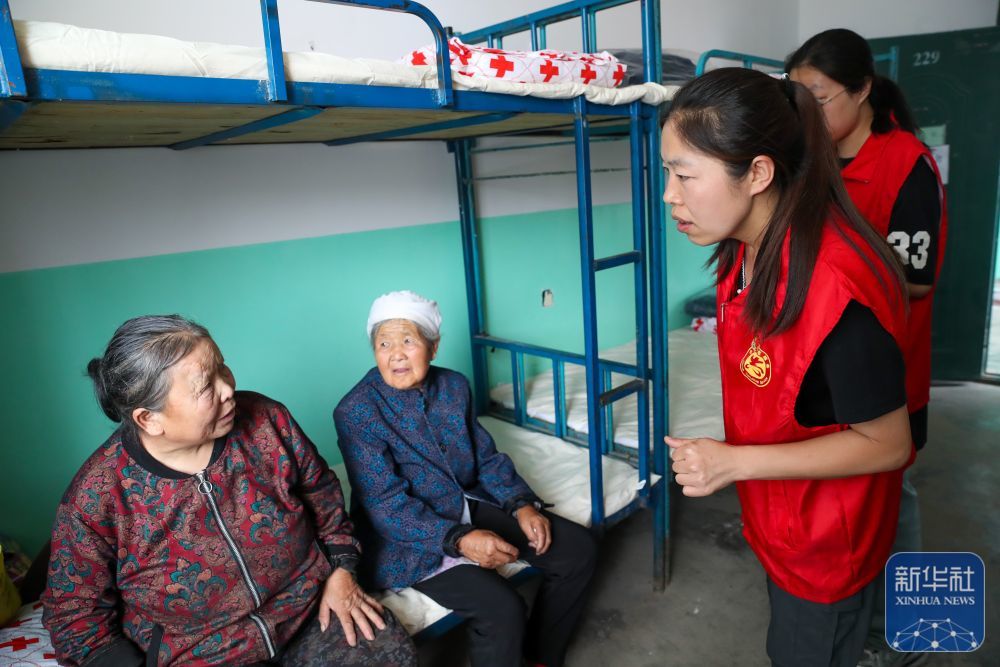 8月9日，在榆中县第三中学安置点，志愿者和受灾群众交流。