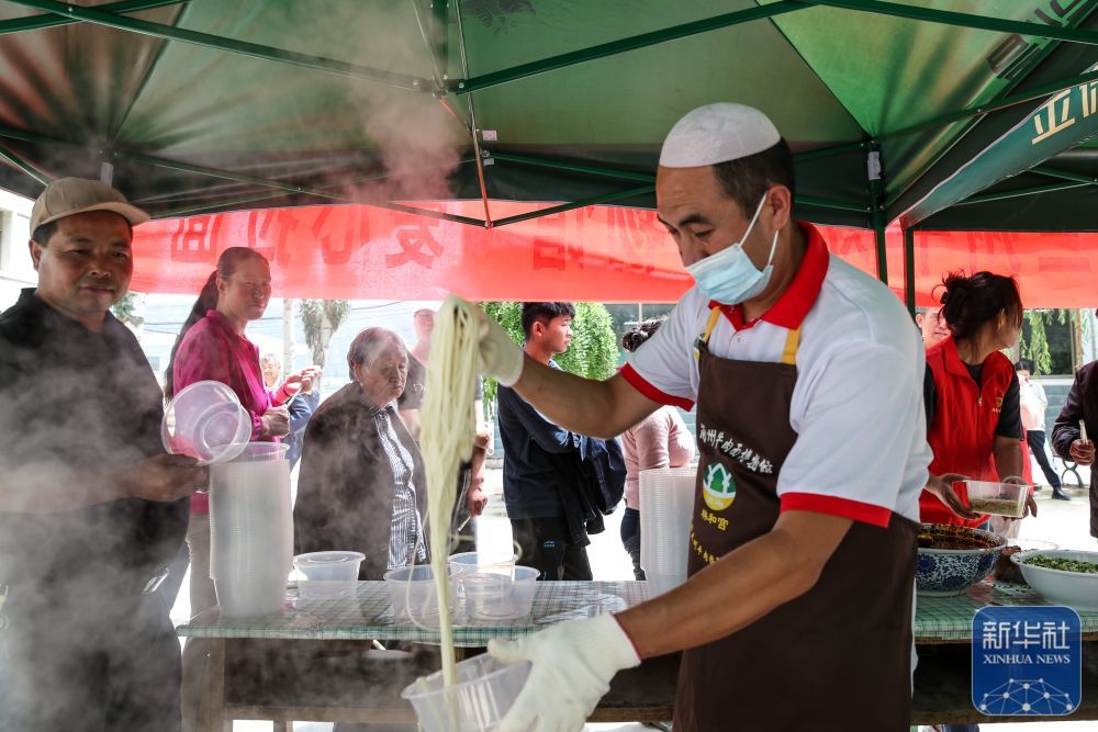 8月9日，在榆中县第三中学安置点，爱心牛肉面企业工作人员为受灾群众准备面食。