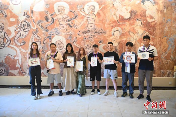 8月1日，在位于甘肃省敦煌市的莫高学堂内，两岸婚生子女暑期研学活动成员展示自己的敦煌壁画临摹作品。2025年7月27日至8月2日，“不负青春　圆梦未来”中华全国台湾同胞联谊会2025年两岸婚生子女暑期研学活动走进甘肃，感受当地丰富的历史文化及产业发展等。中新社记者　李亚龙　摄