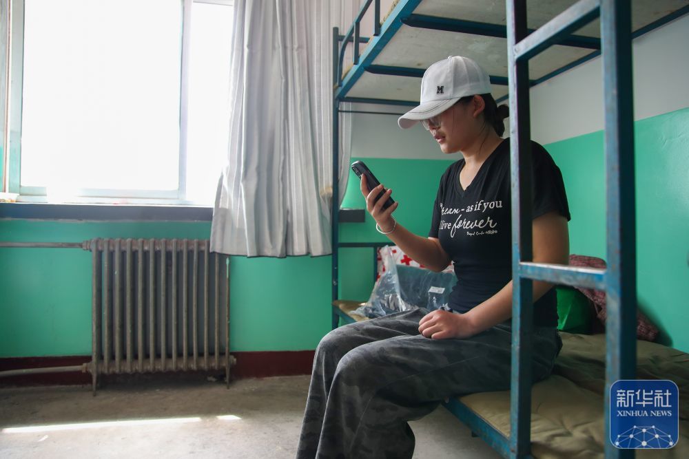 8月9日，在榆中县第三中学安置点宿舍，受灾人员通过视频电话向好友报平安。