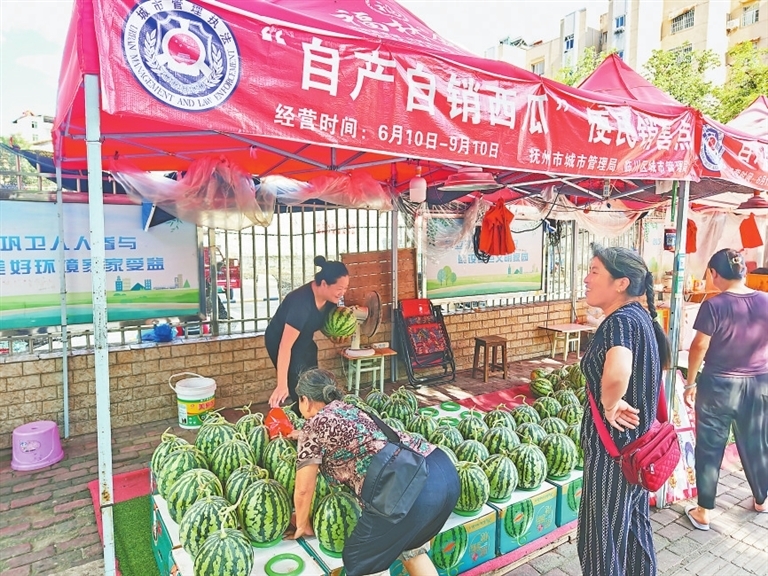 群众在销售点买西瓜。　　本报全媒体记者 蔡颖辉摄