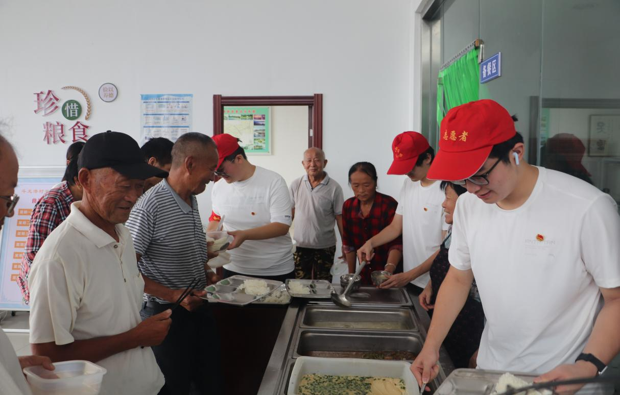 图为“渔之火”乡村振兴团在长者食堂为老人们打饭 徐庆培 供图