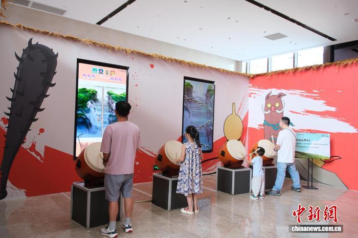 8月9日，游客在《浪浪山小妖怪》主题展内体验“击鼓打小妖”项目。曹丹　摄