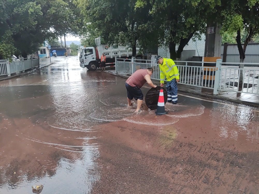 ▲8月10日下午，合川区东津沱红绿灯路口附近，雨后有少量积水，交巡警正在清理积水并维护交通秩序。合川区应急管理局供图