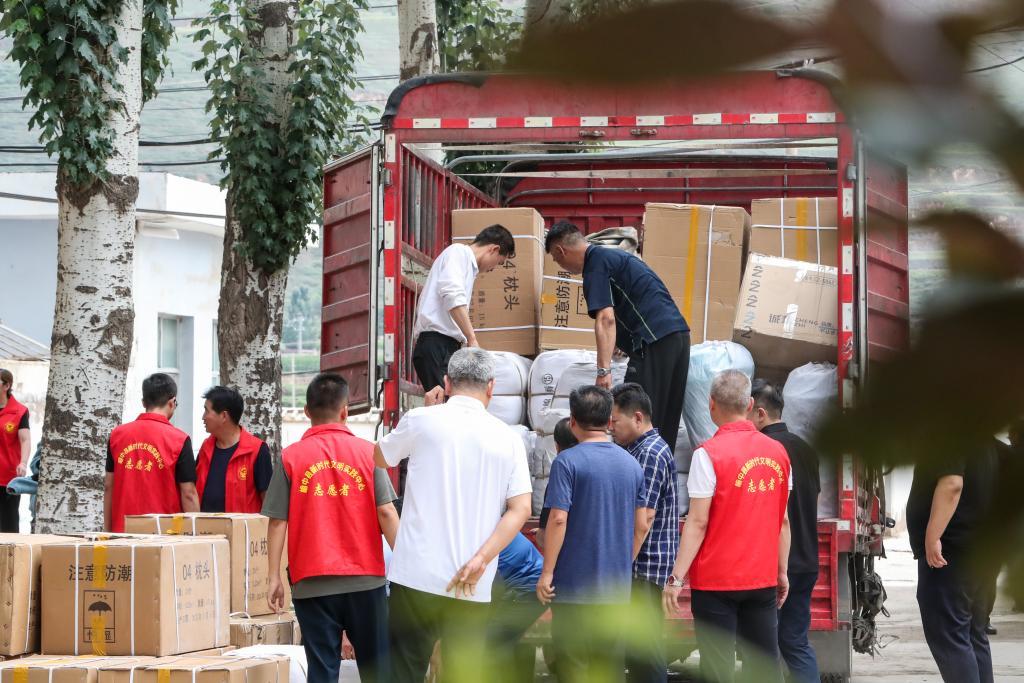 8月9日，在榆中县第三中学安置点，工作人员和志愿者在搬运物资。新华社记者　郎兵兵　摄