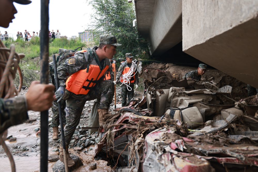 8月9日，武警甘肃总队兰州支队官兵在兰州市榆中县城河道搜索受灾村民丢失物资。新华社发（裴文康　摄）