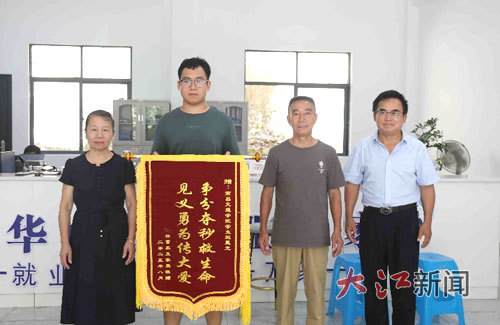 村民林雪英將一面錦旗送到大學生鮑星光手中。