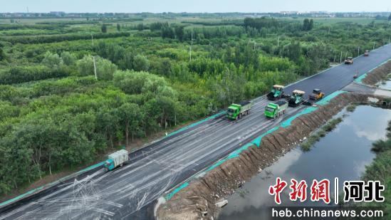 图为任丘市胜利路,工人正在进行沥青铺设作业。 韩慧峰 摄