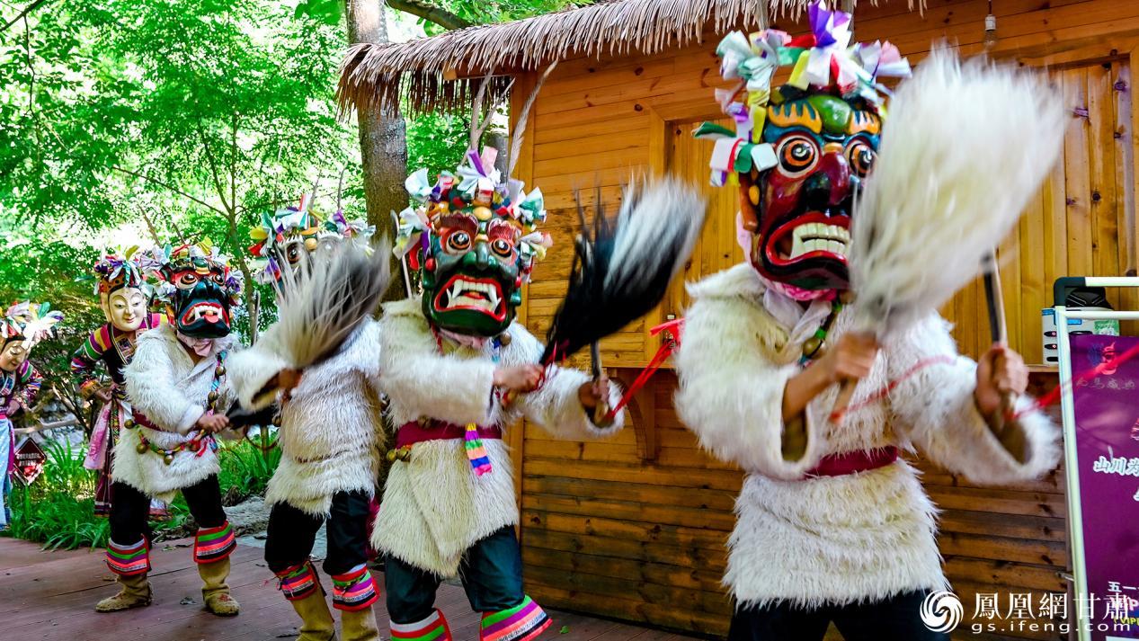 头戴木雕面具的“池哥”“池母”踏着密集的鼓点在村寨间起舞