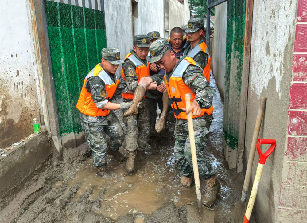 8月9日，武警甘肃总队机动支队官兵在兰州市榆中县城关镇兴隆山村转移受灾群众。新华社发（赵锡强　摄）