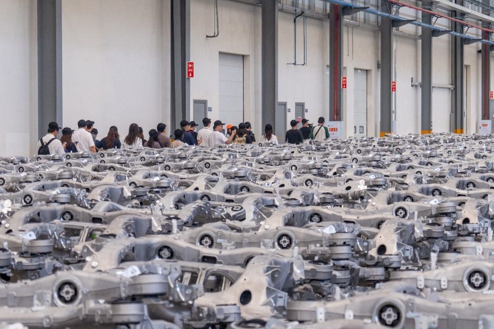 ▲记者团走进拓普公司底盘车间进行采访调研。