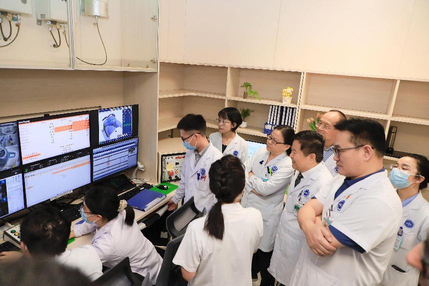 ▲中国医学科学院肿瘤医院深圳医院院长王绿化、副院长昌盛、党委副书记盛修贵、质子放疗中心主任金晶等领导在质子治疗室实时观察张姐治疗情况