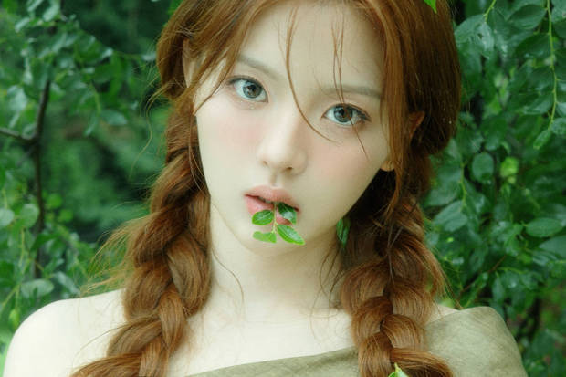 杨超越口含绿叶拍照，好清新的感觉。