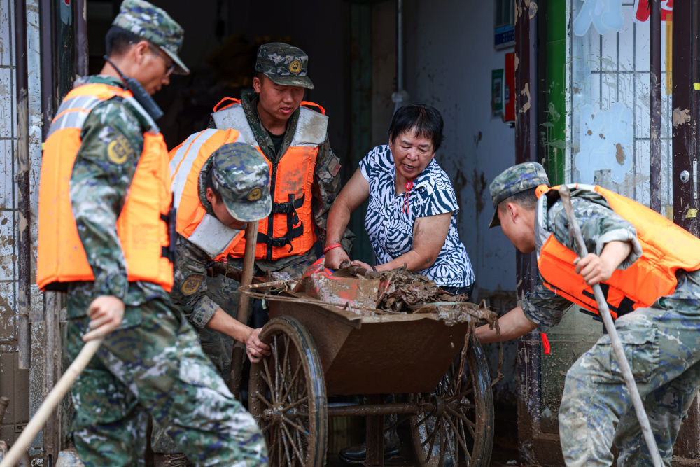 8月9日，武警甘肃总队机动支队官兵在兰州市榆中县城关镇兴隆山村清理杂物。新华社发（侯崇慧　摄）