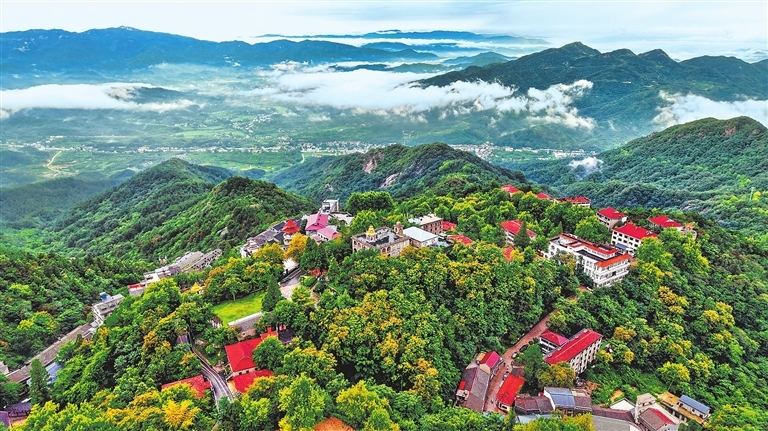 8月13日上午，一场大雨过后，信阳市鸡公山景区云雾缭绕，浓密森林更显苍翠，勾勒出一幅清凉沁心的山水画卷。郝光 摄