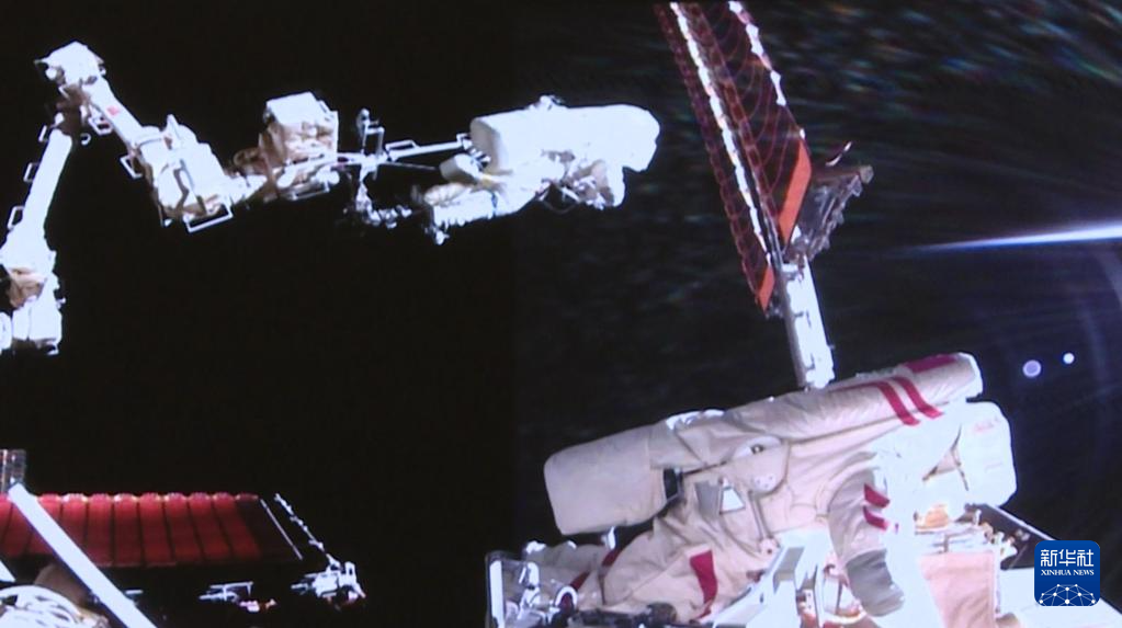 这是8月15日在北京航天飞行控制中心屏幕上拍摄的神舟二十号乘组航天员陈冬（左）与王杰在舱外工作的画面（视频截图）。新华社记者 殷家捷 摄