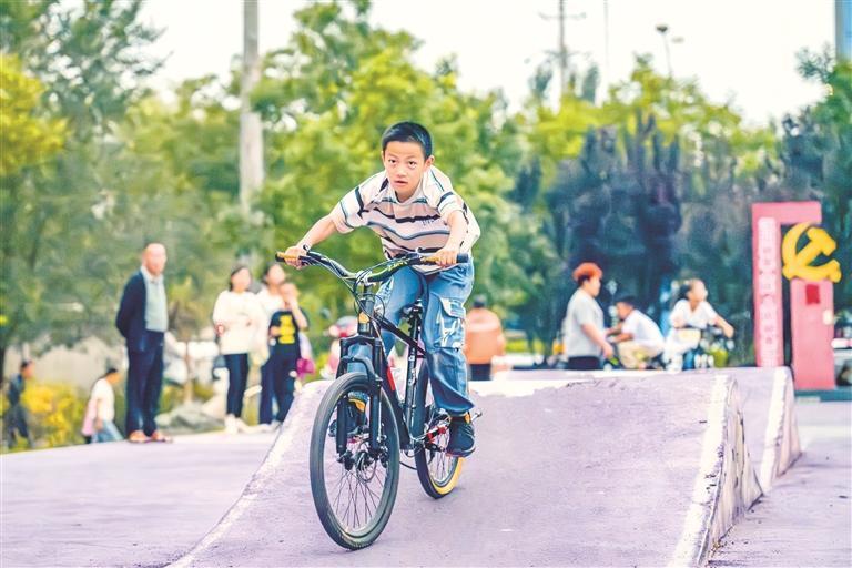 体育公园里少年骑着自行车驶过波浪坡