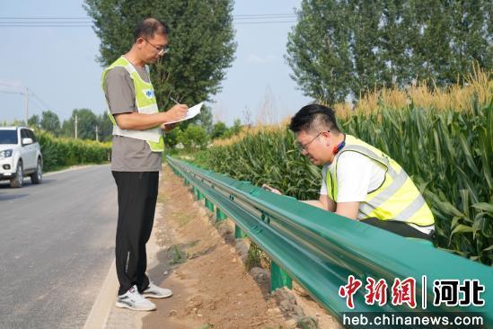 图为任丘市辛中驿镇一乡村道路,工作人员正在检查验收路面建设。 韩慧峰 摄