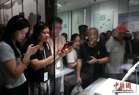 　　游客在山东博物馆展厅欣赏文物“亚醜钺”。陈宛婷 摄