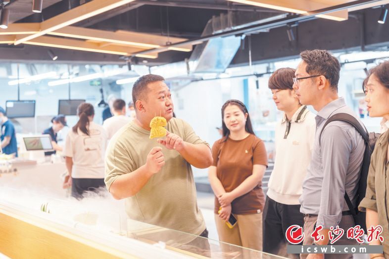 梁文欣(右五)在向前来考察的客商展示他腌制的烤串食材。长沙晚报全媒体记者 邓迪 摄