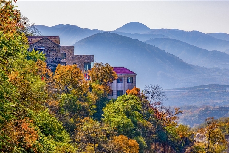 鶴壁市鶴山區(qū)姬家山鄉(xiāng)西頂村特色建筑掩映在山間，錯(cuò)落有致的屋舍與層巒疊嶂的遠(yuǎn)山構(gòu)成一幅靜謐的山居圖景。 受訪者供圖