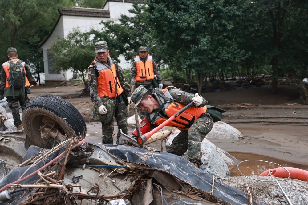 8月9日，武警甘肃总队兰州支队官兵在兰州市榆中县城河道搜索受灾村民丢失物资。新华社发（裴文康　摄）
