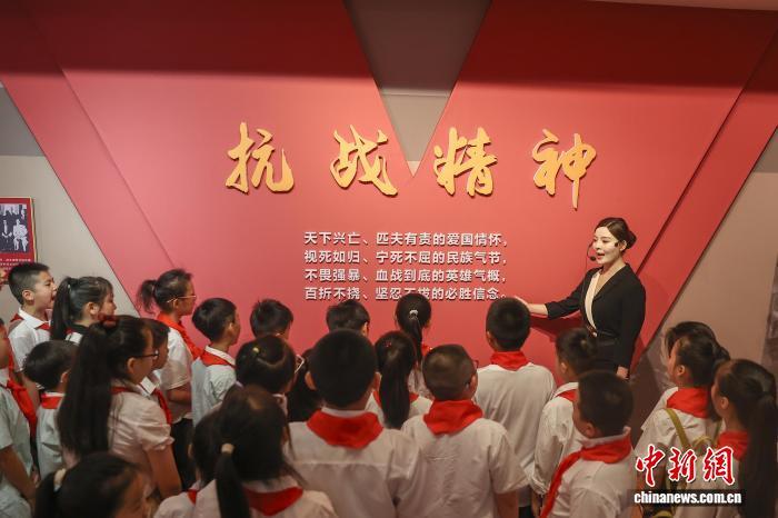8月15日，江西南昌，一群學生在南昌新四軍軍部舊址陳列館聆聽講解員講解。中新社記者 劉力鑫 攝