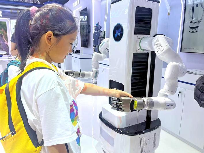 一位小观众和湖北造机器人握手 摄影:楚天都市报极目新闻记者刘洁