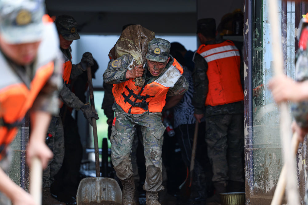 8月9日，武警甘肃总队机动支队官兵在兰州市榆中县城关镇兴隆山村帮助受灾群众转移物资。新华社发（侯崇慧　摄）