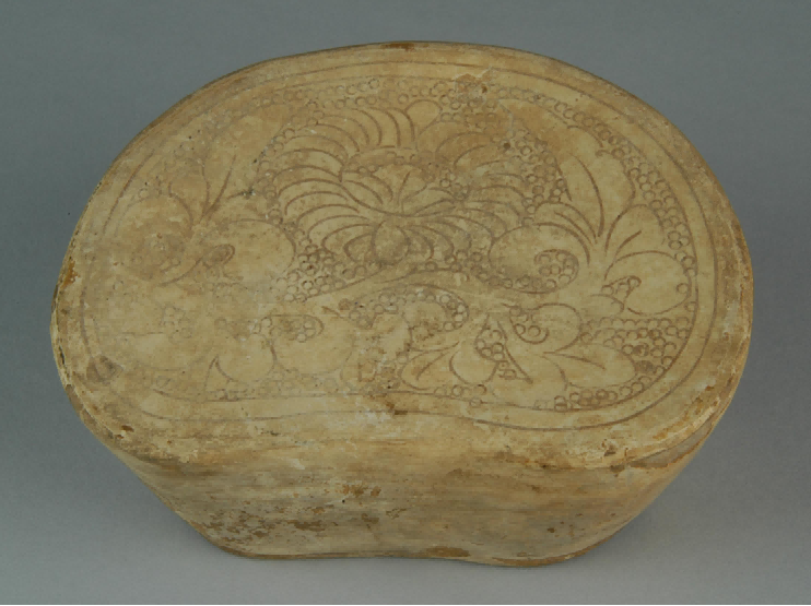 (图二十五,白釉珍珠地缠枝花卉纹枕,宋代,现藏郏县博物馆)