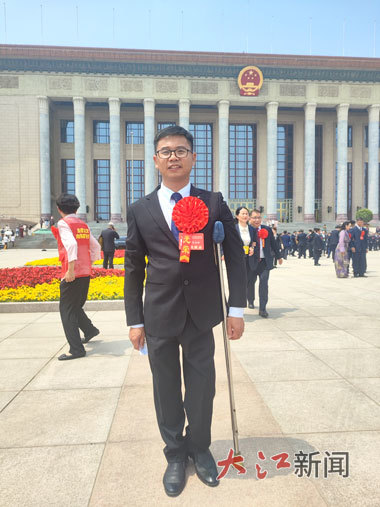 5月16日，第七次全國自強模范暨助殘先進表彰大會召開，吳啟琳在人民大會堂前拍照留念。(受訪者供圖)
