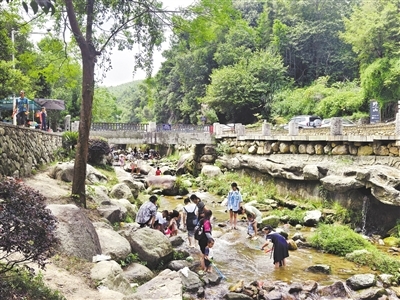 連日來，南昌持續高溫天氣，在灣里管理局太平鎮楠坪古村，一處溯溪地吸引大批市民游客。大人們聊天、享用美食，小孩們在溪水中嬉戲，清涼的溪水給大家帶來了歡樂的時光，也為古村帶來了人氣和消費。洪觀新聞記者 喻云亮 攝