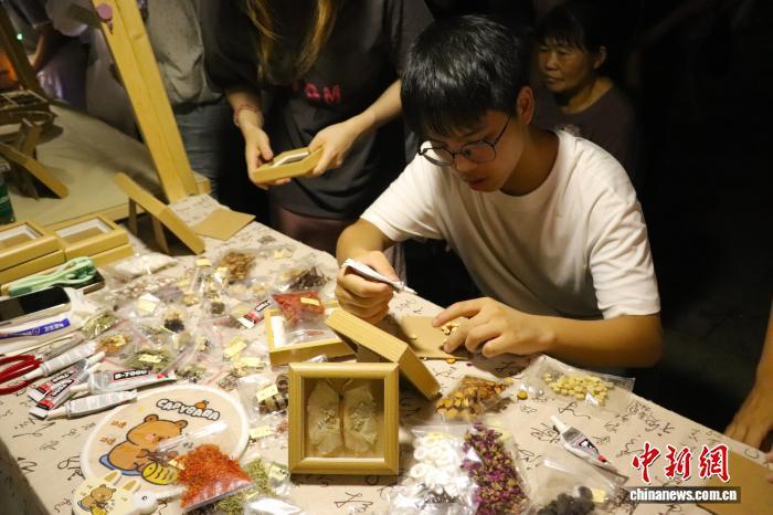 一位少年正在制作中草藥貼畫。 熊錦陽 攝