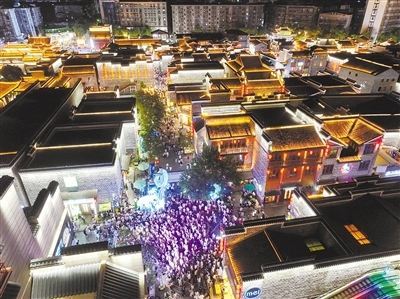 昨日，夜幕降臨，熱氣漸消。萬壽宮歷史文化街區人聲鼎沸，古色古香的街區在流光溢彩的燈光映射下美輪美奐，市民游客趁著夜間漫步其中消暑游玩，不時駐足打卡網紅點位，感受城市歷史韻味與現代活力的碰撞。洪觀新聞記者 成奔 攝