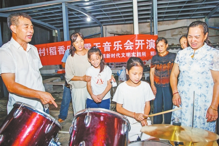村民們看完演出后，興致勃勃地體驗(yàn)起了架子鼓。